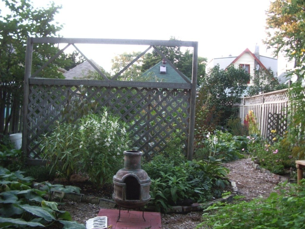 Leafy back garden with a lattice screen and a clay chiminea