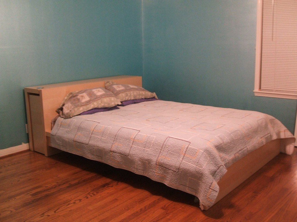 Warm hardwood floor in a bedroom with teal walls
